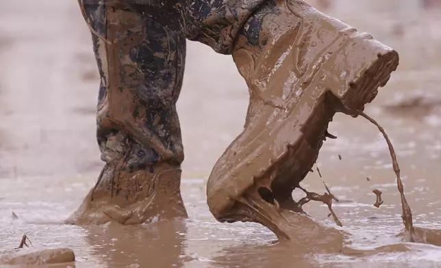 A person walks in the mud after floods in Paiporta, near Valencia, Spain, Monday, Nov. 4, 2024. (AP Photo/Alberto Saiz)