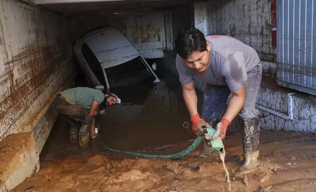 Residents clean their house affected by floods in Valencia, Spain, Thursday, Oct. 31, 2024. (AP Photo/Alberto Saiz)