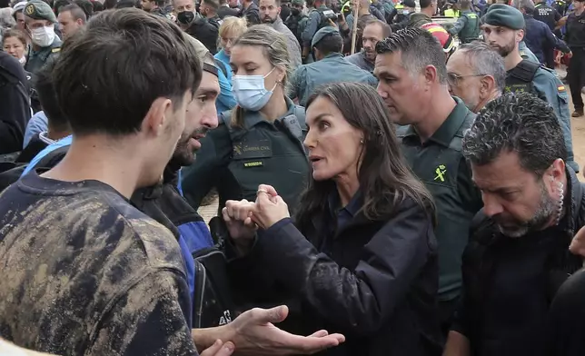 Spain's Queen Letizia speaks with people affected by the floods after crowd of angry survivors of Spain's floods tossed mud and shouted insults at the Spain's King Felipe and government officials when they made their first visit to one of the hardest hit towns. after floods in Paiporta near Valencia, Spain, Sunday, Nov. 3, 2024. (AP Photo/Hugo Torres)