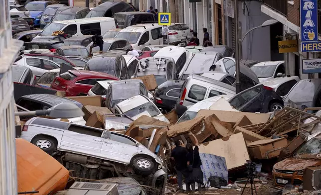 Vehicles are seen piled up after being swept away by floods in Valencia, Spain, Thursday, Oct. 31, 2024. (AP Photo/Alberto Saiz)