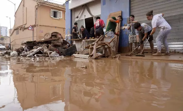 Residents clean their house affected by floods in Valencia, Spain, Thursday, Oct. 31, 2024. (AP Photo/Alberto Saiz)