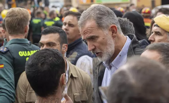 Spain's King Felipe VI speaks with people amidst angry Spanish flood survivors in Paiporta, near Valencia, Spain, Sunday Nov. 3, 2024. (AP Photo/David Melero)