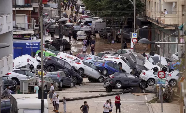 Vehicles are seen piled up after being swept away by floods in Valencia, Spain, Thursday, Oct. 31, 2024. (AP Photo/Alberto Saiz)