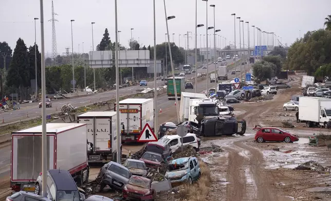 Cars are strewn on the side on a main road after floods in Valencia, Spain, Friday, Nov. 1, 2024. (AP Photo/Alberto Saiz)