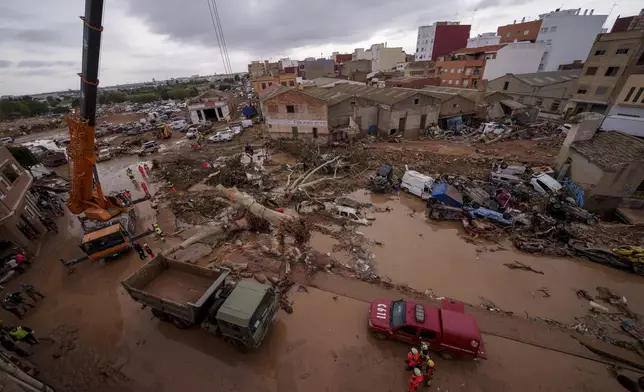 Emergency services remove cars in an area affected by floods in Catarroja, Spain, on Sunday, Nov. 3, 2024. (AP Photo/Manu Fernandez)