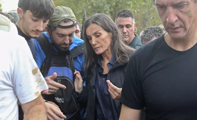 Spain's Queen Letizia speaks with people affected by the floods after crowd of angry survivors of Spain's floods tossed mud and shouted insults at the Spain's King Felipe and government officials when they made their first visit to one of the hardest hit towns. after floods in Paiporta near Valencia, Spain, Sunday, Nov. 3, 2024. (AP Photo/Hugo Torres)