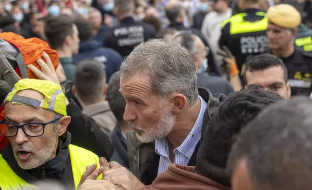 Spain's King Felipe VI speaks with people amidst angry Spanish flood survivors in Paiporta, near Valencia, Spain, Sunday Nov. 3, 2024. (AP Photo/David Melero)