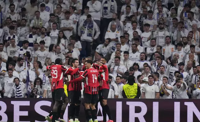 AC Milan's Tijjani Reijnders (14) celebrates with teammates after scoring his side's 3rd goal against Real Madrid during the Champions League opening phase soccer match at the Santiago Bernabeu stadium in Madrid, Spain, Tuesday, Nov. 5, 2024. (AP Photo/Manu Fernandez)