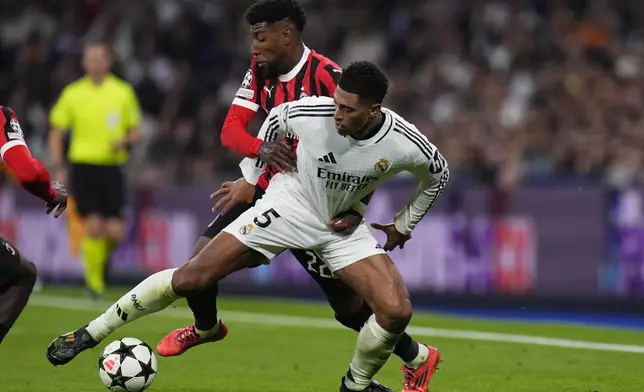 Real Madrid's Jude Bellingham, front, and AC Milan's Emerson Royal battle for the ball during the Champions League opening phase soccer match at the Santiago Bernabeu stadium in Madrid, Spain, Tuesday, Nov. 5, 2024. (AP Photo/Manu Fernandez)