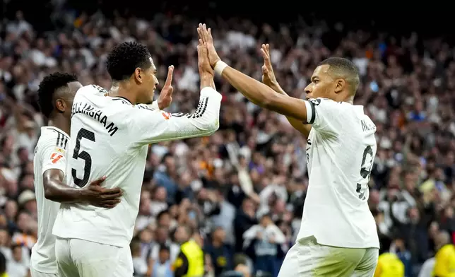 Real Madrid's Jude Bellingham celebrates with Real Madrid's Kylian Mbappe after scoring his side's second goal during the Spanish La Liga soccer match between Real Madrid and Osasuna at the Santiago Bernabeu stadium in Madrid, Spain, Saturday, Nov. 9, 2024. (AP Photo/Jose Breton)