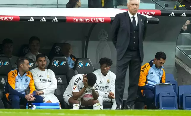 Real Madrid's Rodrygo sits on the bech after an injury during the Spanish La Liga soccer match between Real Madrid and Osasuna at the Santiago Bernabeu stadium in Madrid, Spain, Saturday, Nov. 9, 2024. (AP Photo/Jose Breton)