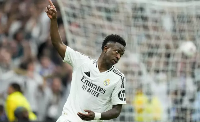 Real Madrid's Vinicius Junior celebrates after scoring his side's first goal during the Spanish La Liga soccer match between Real Madrid and Osasuna at the Santiago Bernabeu stadium in Madrid, Spain, Saturday, Nov. 9, 2024. (AP Photo/Jose Breton)