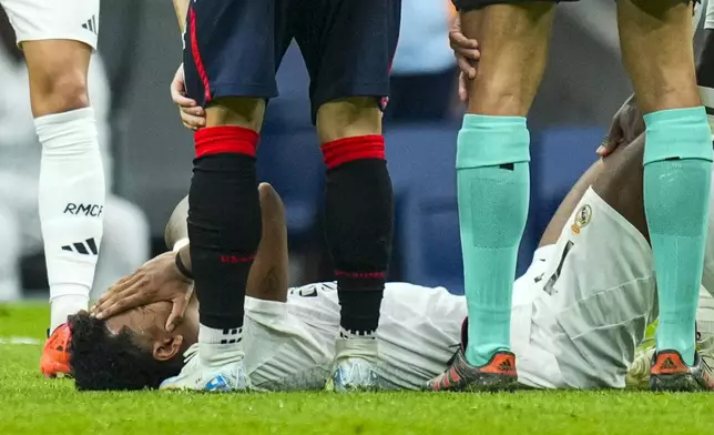 Real Madrid's Rodrygo covers his face after an injury during the Spanish La Liga soccer match between Real Madrid and Osasuna at the Santiago Bernabeu stadium in Madrid, Spain, Saturday, Nov. 9, 2024. (AP Photo/Jose Breton)