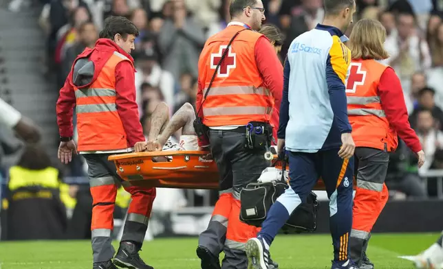 Real Madrid's Eder Militao is stretchered off the pitch after an injury during the Spanish La Liga soccer match between Real Madrid and Osasuna at the Santiago Bernabeu stadium in Madrid, Spain, Saturday, Nov. 9, 2024. (AP Photo/Jose Breton)