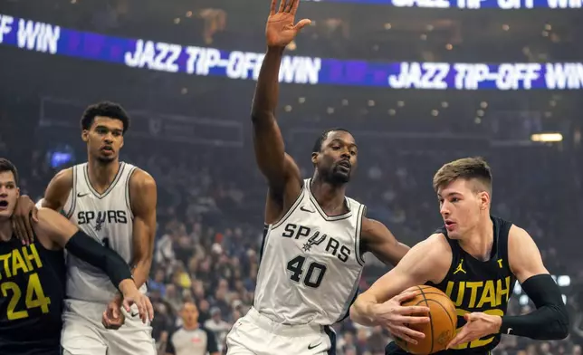 San Antonio Spurs forward Harrison Barnes (40) guards Utah Jazz forward Kyle Filipowski (22), as San Antonio Spurs center Victor Wembanyama (1) guards Utah Jazz center Walker Kessler (24), during the first half of an NBA basketball game, Thursday, Oct. 31, 2024, in Salt Lake City. (AP Photo/Rick Egan)