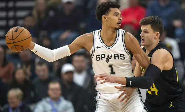 San Antonio Spurs center Victor Wembanyama (1) looks for an outlet as Utah Jazz center Walker Kessler (24) defends during the first half of an NBA basketball game, Thursday, Oct. 31, 2024, in Salt Lake City. (AP Photo/Rick Egan)