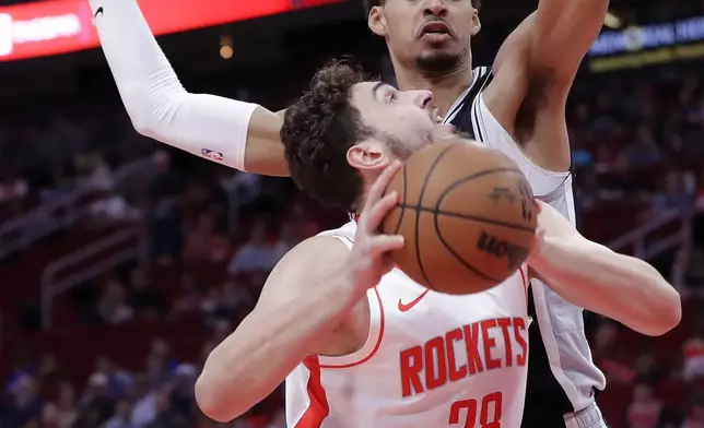 Houston Rockets center Alperen Sengun (28) tries to put up a shot as San Antonio Spurs center Victor Wembanyama, back, defends during the first half of an NBA basketball game Wednesday, Nov. 6, 2024, in Houston. (AP Photo/Michael Wyke)