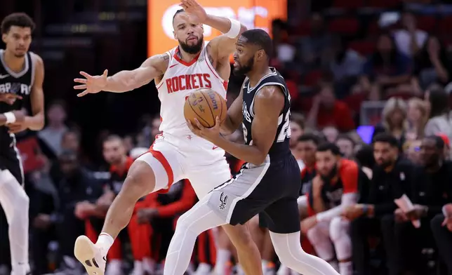 Houston Rockets forward Dillon Brooks, left, attempts to block the pass by San Antonio Spurs guard Malaki Branham, right, during the first half of an NBA basketball game Wednesday, Nov. 6, 2024, in Houston. (AP Photo/Michael Wyke)