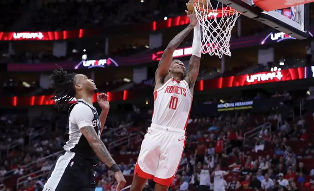 Houston Rockets forward Jabari Smith Jr. (10) dunks the ball over San Antonio Spurs guard Stephon Castle, left, during the first half of an NBA basketball game Wednesday, Nov. 6, 2024, in Houston. (AP Photo/Michael Wyke)