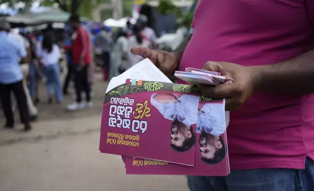 A supporter of National People's Power distributes propaganda material ahead of Thursday's parliamentary election in Dambulla, Sri Lanka, Sunday, Nov.10, 2024. (AP Photo/Eranga Jayawardena)