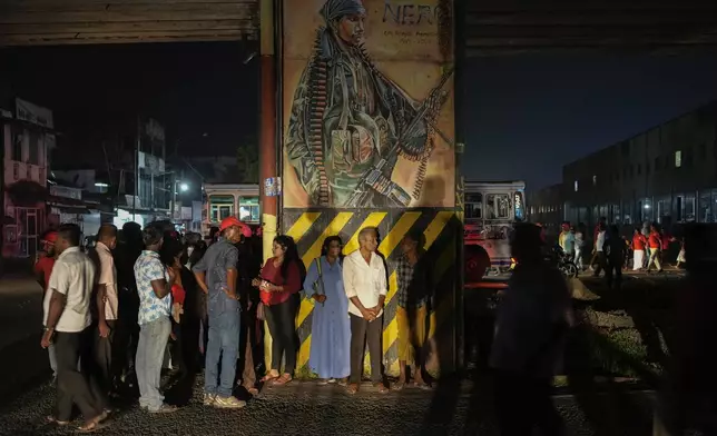 Supporters of Sri Lankan President Anura Kumara Dissanayake wait for transport after a public rally ahead of Thursday's parliamentary election in Gampaha, Sri Lanka, Monday, Nov. 11, 2024. (AP Photo/Eranga Jayawardena)