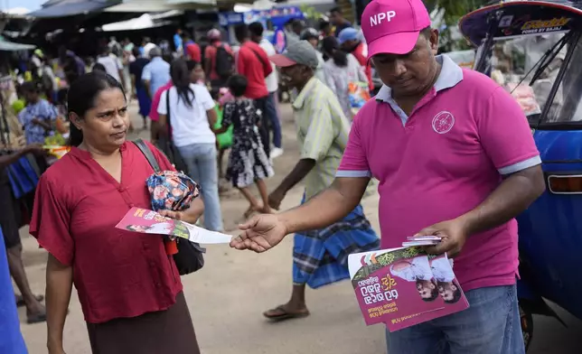 A supporter of National People's Power distributes propaganda material ahead of Thursday's parliamentary election in Dambulla, Sri Lanka, Sunday, Nov.10, 2024.(AP Photo/Eranga Jayawardena)