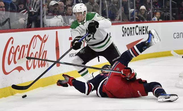 Dallas Stars' Nils Lundkvist (5) skates around Winnipeg Jets' Gabriel Vilardi (13) after checking him off the puck during the second period of an NHL hockey game in Winnipeg, Manitoba, Saturday, Nov. 9, 2024. (Fred Greenslade/The Canadian Press via AP)
