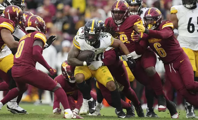 Pittsburgh Steelers running back Jaylen Warren (30) is tackled by the Washington Commanders defense during the second half of an NFL football game, Sunday, Nov. 10, 2024, in Landover, Md. (AP Photo/Stephanie Scarbrough)