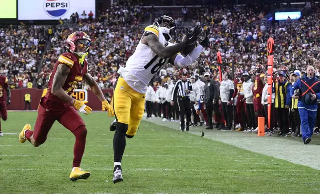 Pittsburgh Steelers wide receiver Mike Williams (18), defended by Washington Commanders cornerback Benjamin St-Juste (25), pulls in a 32-yard reception for a touchdown 'during the second half of an NFL football game, Sunday, Nov. 10, 2024, in Landover, Md. (AP Photo/Nick Wass)