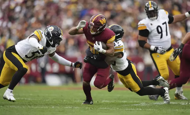 Washington Commanders running back Austin Ekeler (30) is tackled by Pittsburgh Steelers safety DeShon Elliott (25) during the first half of an NFL football game, Sunday, Nov. 10, 2024, in Landover, Md. (AP Photo/Stephanie Scarbrough)