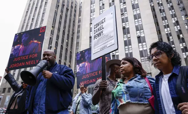 A Protestor speaks before Daniel Penny, the white veteran accused of choking a distressed Black subway rider to death, arrives for opening statements at the court in New York, Friday, Nov. 1, 2024.(AP Photo/Kena Betancur)