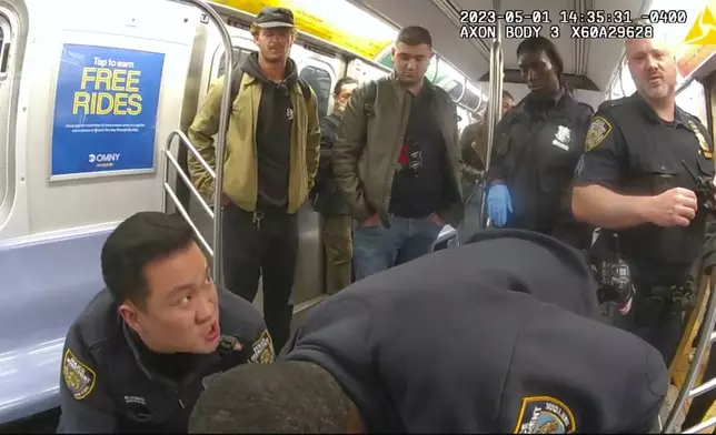 This image from body camera video provided by New York City Police Department, Penny, standing at left, looks on in a New York City subway car as officers attempt to revive Jordan Neely onMay 5, 2023. (New York City Police Department via AP)