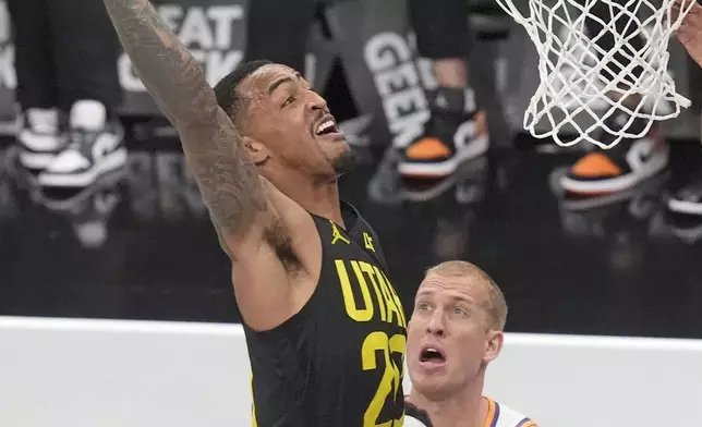 Utah Jazz forward John Collins goes to the basket as Phoenix Suns' Devin Booker, center, Mason Plumlee (22) looks on during the first half of an Emirates NBA Cup basketball game Tuesday, Nov. 12, 2024, in Salt Lake City. (AP Photo/Rick Bowmer)