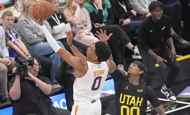 Phoenix Suns forward Ryan Dunn (0) goes to the basket as Utah Jazz guard Jordan Clarkson (00) defends during the first half of an Emirates NBA Cup basketball game, Tuesday, Nov. 12, 2024, in Salt Lake City. (AP Photo/Rick Bowmer)