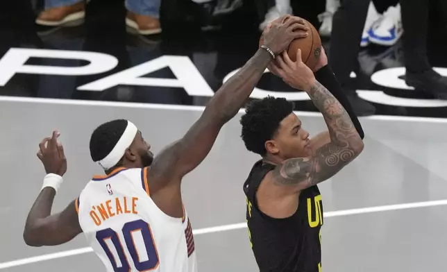 Phoenix Suns forward Royce O'Neale (00) blocks the shot from Utah Jazz guard Keyonte George during the first half of an Emirates NBA Cup basketball game, Tuesday, Nov. 12, 2024, in Salt Lake City. (AP Photo/Rick Bowmer)