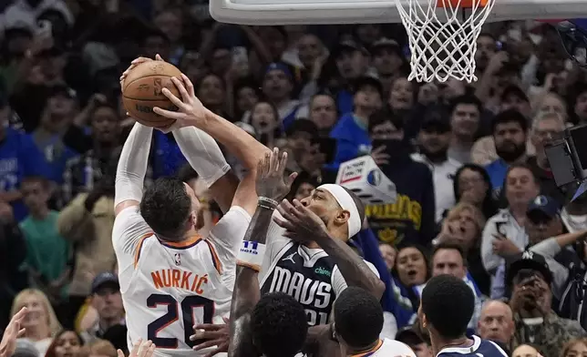 Phoenix Suns center Jusuf Nurkic (20) is founded by Dallas Mavericks center Daniel Gafford (21) in the final second of the second half of an NBA basketball game Friday, Nov. 8, 2024, in Dallas. (AP Photo/LM Otero)