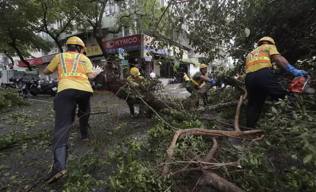 Sanitation workers of Taipei city government clear debris in the aftermath of Typhoon Kong-rey in Taipei, Taiwan, Friday, Nov. 1, 2024. (AP Photo/Chiang Ying-ying)