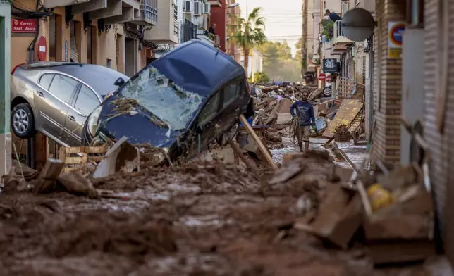 FILE - A man walks through a street affected by floods in Valencia, Spain, Saturday, Nov. 2, 2024. (AP Photo/Manu Fernandez, File)