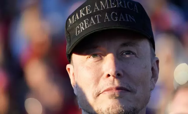 FILE - Tesla and SpaceX CEO Elon Musk listens as Republican presidential nominee former President Donald Trump speaks at a campaign event at the Butler Farm Show, Oct. 5, 2024, in Butler, Pa. (AP Photo/Alex Brandon, File)