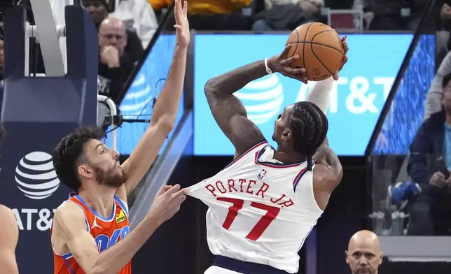 Los Angeles Clippers guard Kevin Porter Jr., right, shoots as Oklahoma City Thunder forward Chet Holmgren pulls his jersey during the first half of an NBA basketball game, Saturday, Nov. 2, 2024, in Inglewood, Calif. (AP Photo/Mark J. Terrill)