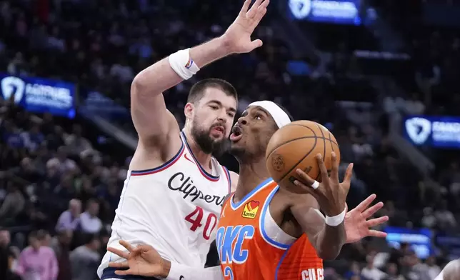 Oklahoma City Thunder guard Shai Gilgeous-Alexander, right, shoots as Los Angeles Clippers center Ivica Zubac defends during the first half of an NBA basketball game, Saturday, Nov. 2, 2024, in Inglewood, Calif. (AP Photo/Mark J. Terrill)