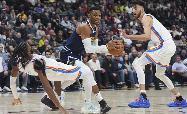 Denver Nuggets guard Russell Westbrook, center, fouls Oklahoma City Thunder guard Isaiah Joe, left, as forward Chet Holmgren looks on in the first half of an NBA basketball game Wednesday, Nov. 6, 2024, in Denver. (AP Photo/David Zalubowski)