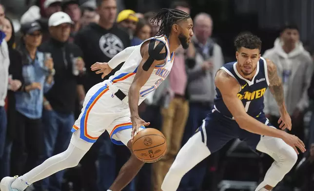 Oklahoma City Thunder guard Isaiah Joe, left, drives past Denver Nuggets forward Michael Porter Jr. defends in the first half of an NBA basketball game Wednesday, Nov. 6, 2024, in Denver. (AP Photo/David Zalubowski)