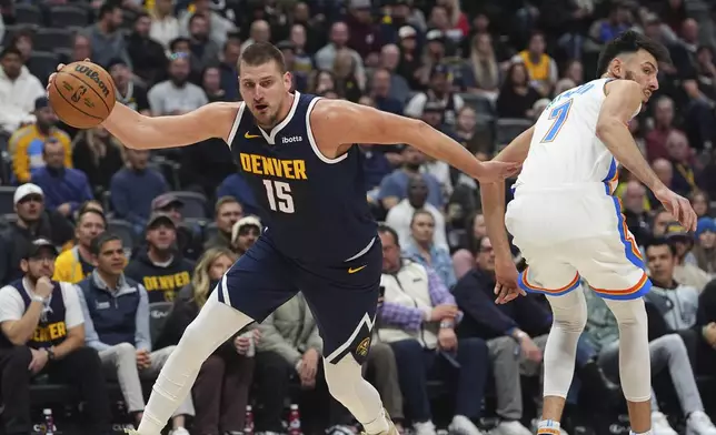 Denver Nuggets center Nikola Jokic, left, drives past Oklahoma City Thunder forward Chet Holmgren in the first half of an NBA basketball game Wednesday, Nov. 6, 2024, in Denver. (AP Photo/David Zalubowski)