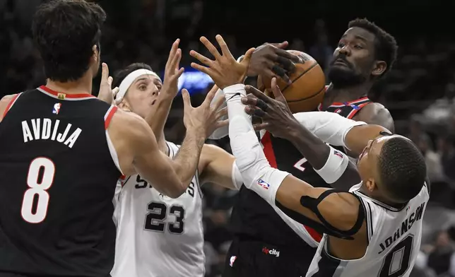 San Antonio Spurs' Zach Collins (23) and Keldon Johnson (0) tangle with Portland Trail Blazers' Deni Avdija (8) and Deandre Ayton during the second half of an NBA basketball game, Thursday, Nov. 7, 2024, in San Antonio. San Antonio won 118-105. (AP Photo/Darren Abate)