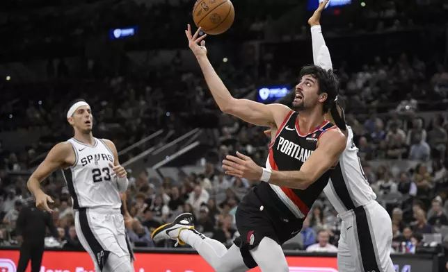 Portland Trail Blazers' Deni Avdija attempts to shoot as he is defended by San Antonio Spurs' Keldon Johnson, right, during the first half of an NBA basketball game, Thursday, Nov. 7, 2024, in San Antonio. (AP Photo/Darren Abate)