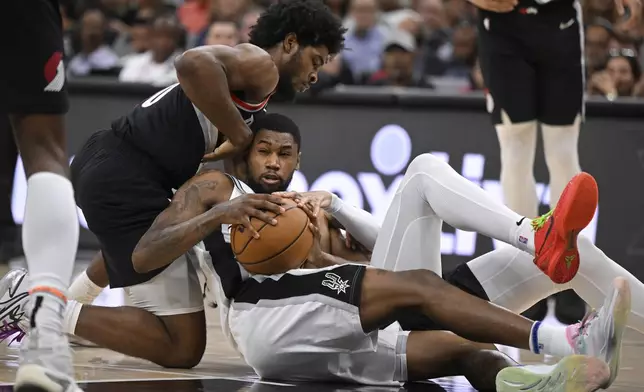 San Antonio Spurs' Blake Wesley, center, tangles with Portland Trail Blazers' Scoot Henderson, left, and Dalano Banton during the second half of an NBA basketball game, Thursday, Nov. 7, 2024, in San Antonio. San Antonio won 118-105. (AP Photo/Darren Abate)