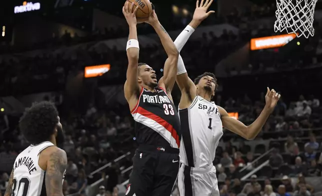 Portland Trail Blazers' Toumani Camara (33) goes to the basket against San Antonio Spurs' Victor Wembanyama (1) during the first half of an NBA basketball game, Thursday, Nov. 7, 2024, in San Antonio, Texas. (AP Photo/Darren Abate)