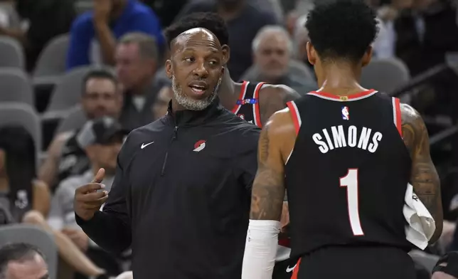 Portland Trail Blazers head coach Chauncey Billups, left, speaks with Portland guard Anfernee Simons during the first half of an NBA basketball game against the San Antonio Spurs, Thursday, Nov. 7, 2024, in San Antonio. (AP Photo/Darren Abate)