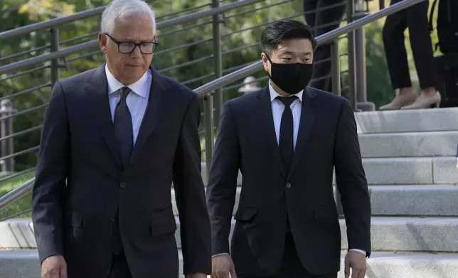 FILE - Attorney David Sanford, left, and Young Lee, right, brother of murder victim Hae Min Lee, walk over to talk with reporters outside Maryland's Supreme Court in Annapolis, Md., Oct. 5, 2023, following arguments in an appeal by Adnan Syed, whose conviction for killing his ex-girlfriend Hae Min Lee more than 20 years ago was chronicled in the hit podcast "Serial." (AP Photo/Susan Walsh, File)